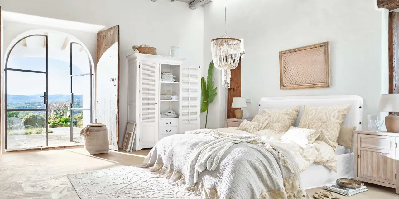 Elegantes dormitorio ideas con cama grande, armario blanco y puertas abiertas a un paisaje soleado.
