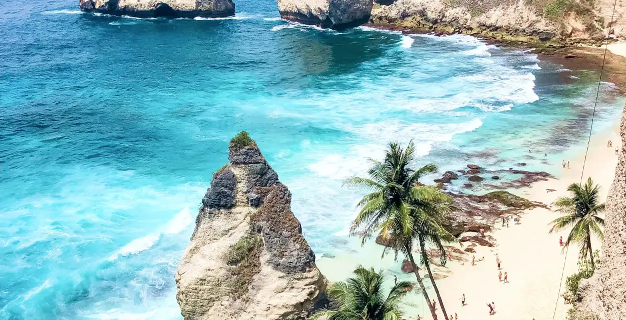 Rajska plaża z palmami i turkusową wodą. Zastanawiasz się, ile się leci na Bali, by zobaczyć taki widok?
