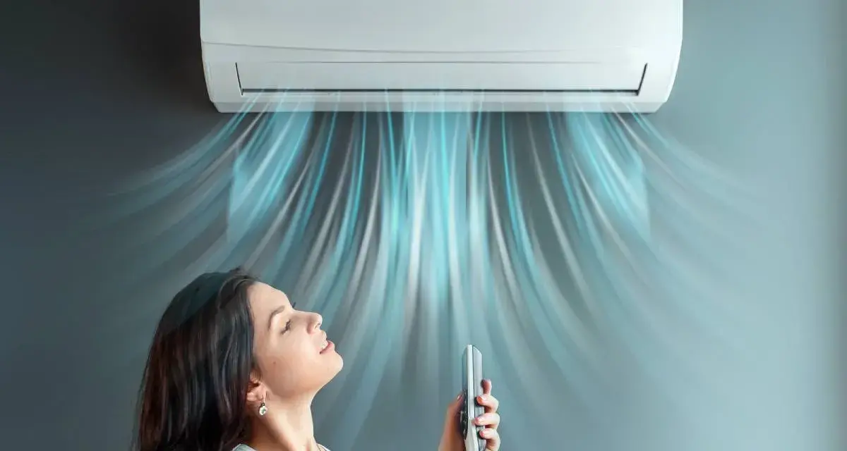 Donna rilassata sotto l'aria fresca di un climatizzatore inverter, che ne spiega il significato di comfort e risparmio energetico.