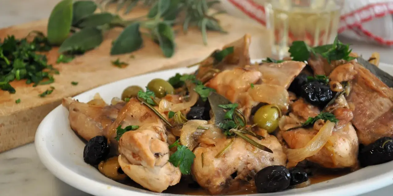 Piatto di coniglio alla cacciatora in bianco, con olive, cipolle e rosmarino. Un classico della cucina italiana.