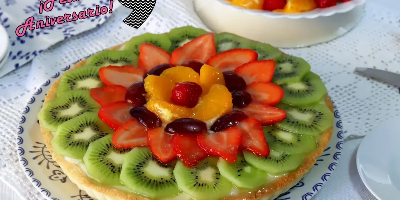 ¡Feliz Aniversario! Una deliciosa tarta de frutas con kiwi, fresas, naranja y uvas.