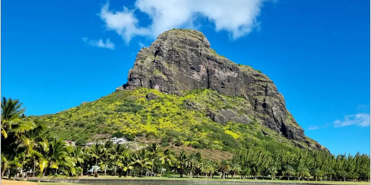 Mauritius pogoda marzec: majestatyczna góra porośnięta zielenią, palmy, jezioro i błękitne niebo.