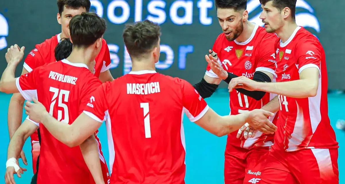 Polska drużyna siatkówki w czerwonych strojach, zawodnicy z numerami 75 i 1, omawiają taktykę.