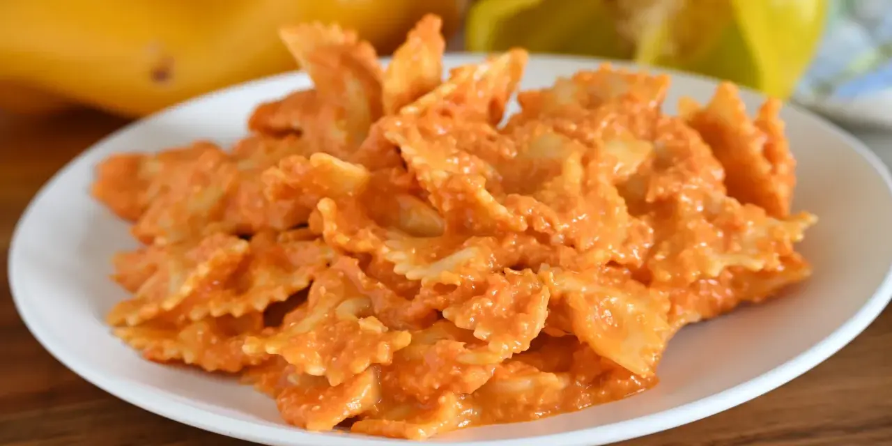 Farfalle condite con una cremosa salsa ai peperoni, un piatto colorato e gustoso.