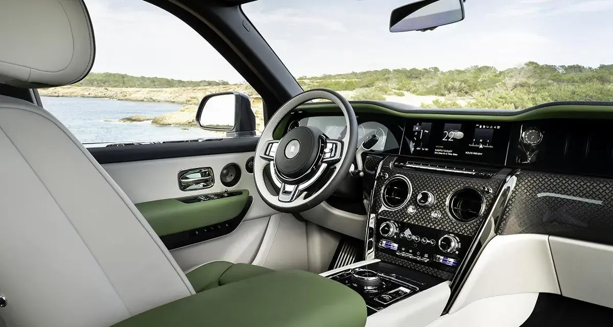Wnętrze luksusowego Rolls-Royce SUV z zielonymi i białymi skórzanymi detalami, widok na morze.