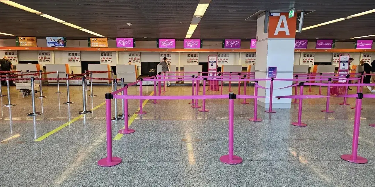 Puste stanowiska Wizzair, gdzie trwa odprawa. Różowe taśmy wyznaczają kolejkę do lotu.