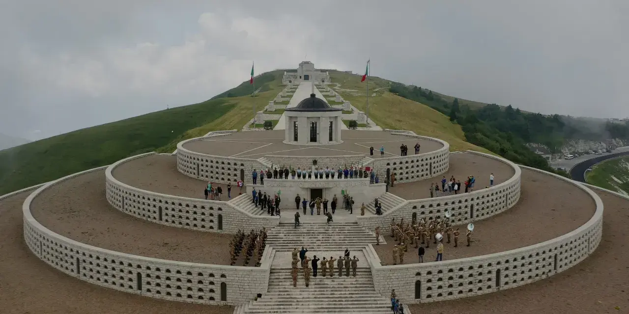 Monumento ai caduti sul Monte Grappa, Prima Guerra Mondiale. Una banda militare suona mentre soldati rendono omaggio.