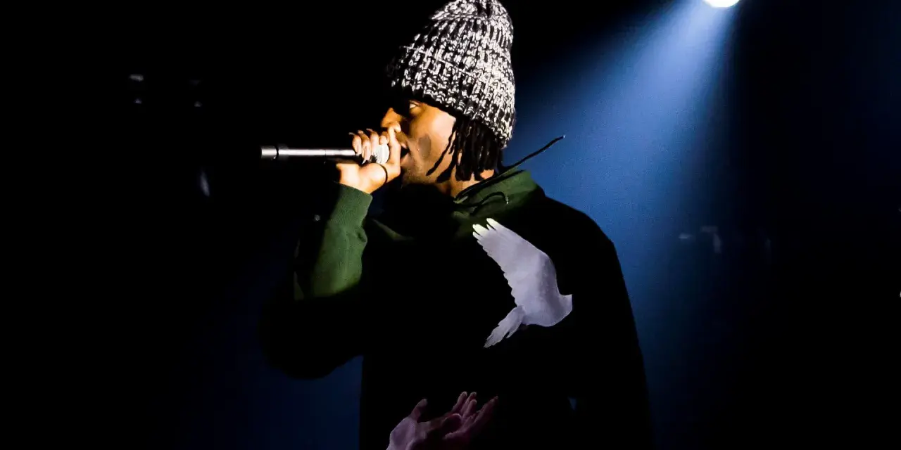 Playboi Carti Polska na scenie, w czapce i bluzie z gołębiem.