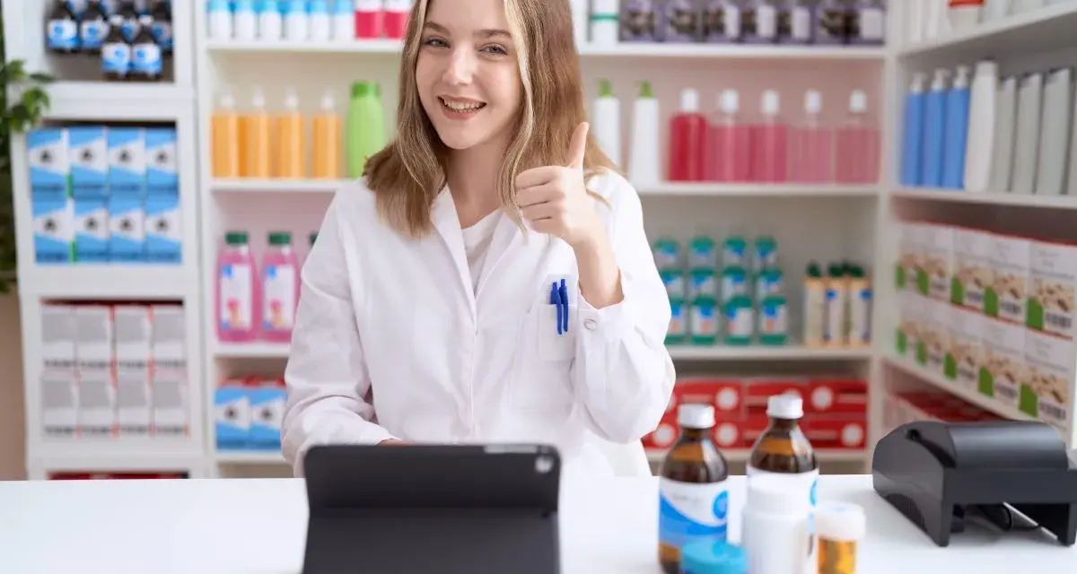 Farmaceutka z uśmiechem pokazuje kciuk w górę, potwierdzając, czy apteka może wydać lek bez recepty.