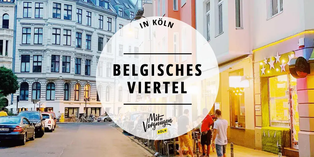 Abendstimmung im Belgischen Viertel in Köln. Menschen sitzen vor beleuchteten Geschäften, Autos parken am Straßenrand.