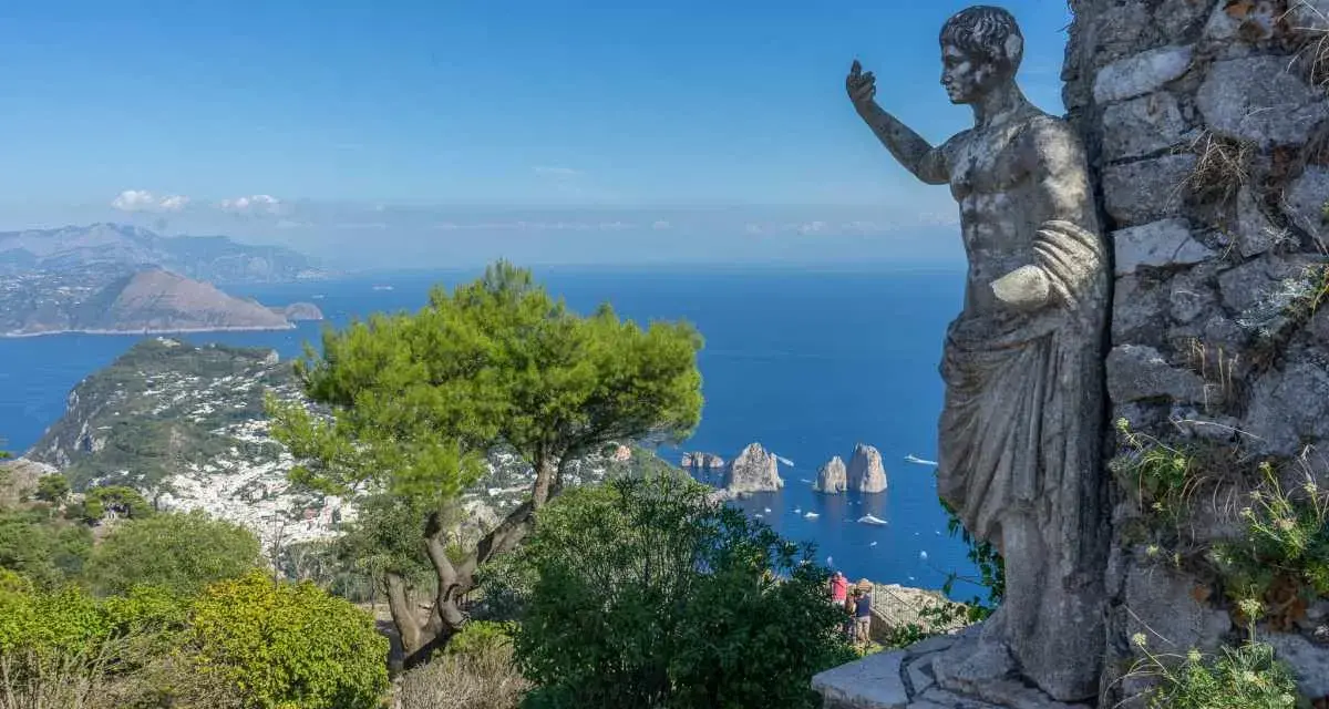 Statua antica domina il panorama mozzafiato di Capri. Un invito a scoprire cosa visitare a Capri, tra mare blu e Faraglioni.