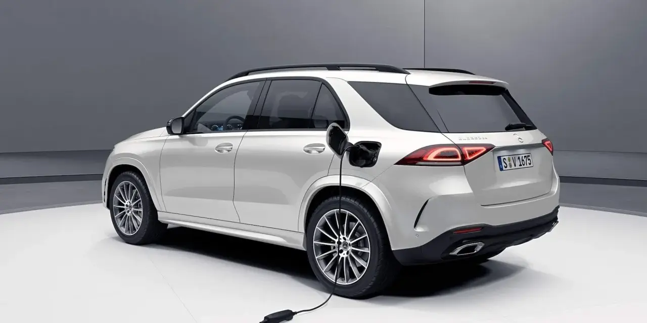 Biały samochód hybrydowy Mercedes-Benz GLE jest ładowany.