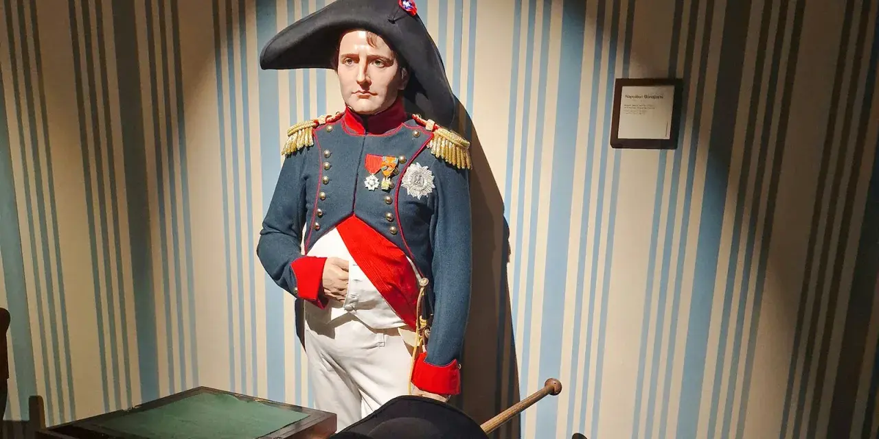Napoleon Bonaparte w muzeum figur woskowych w Paryżu. Jego postać w historycznym mundurze przyciąga wzrok.