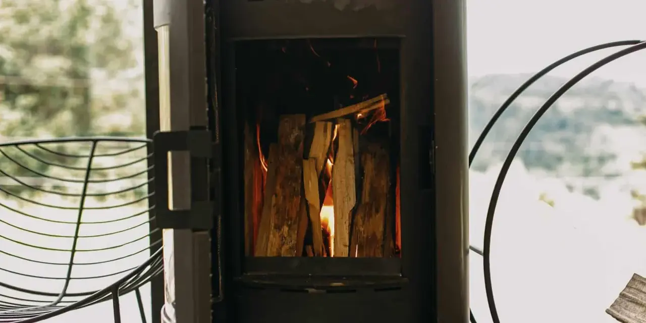Poêle à bois allumé, avec une prise d'air poele à bois obligatoire pour une combustion optimale. Le feu crépite joyeusement.