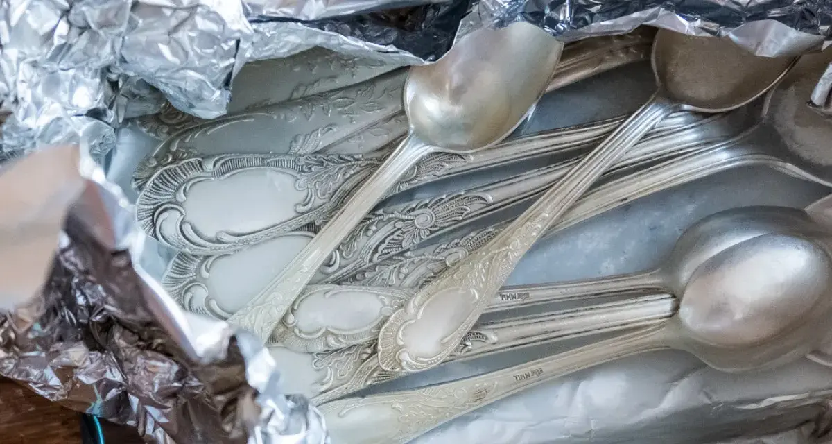Stare, ozdobne łyżki w folii aluminiowej, gotowe do czyszczenia. Dowiedz się, jak wyczyścić srebro, by odzyskało blask.