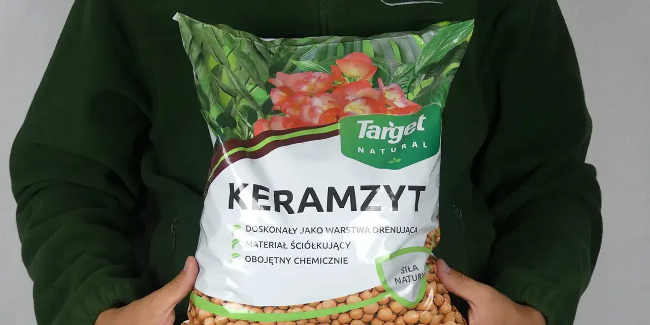 Osoba trzyma worek z napisem "Keramzyt", który jest doskonałym materiałem drenażowym i ściółkującym.