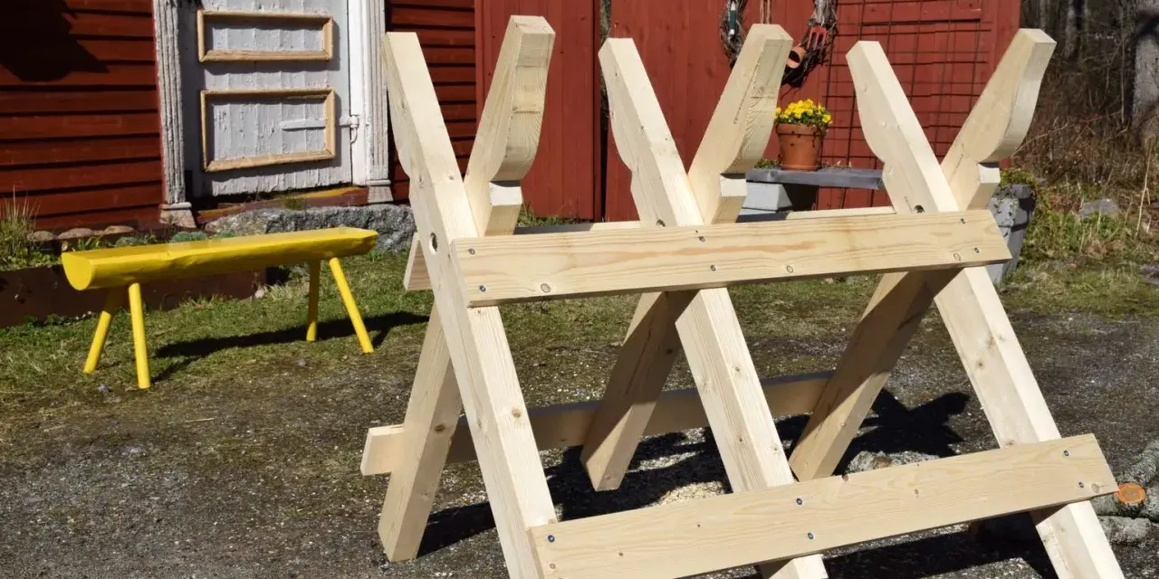 Nybyggd sågbock i trä, redo för att bygga ved. En gul bänk syns i bakgrunden.