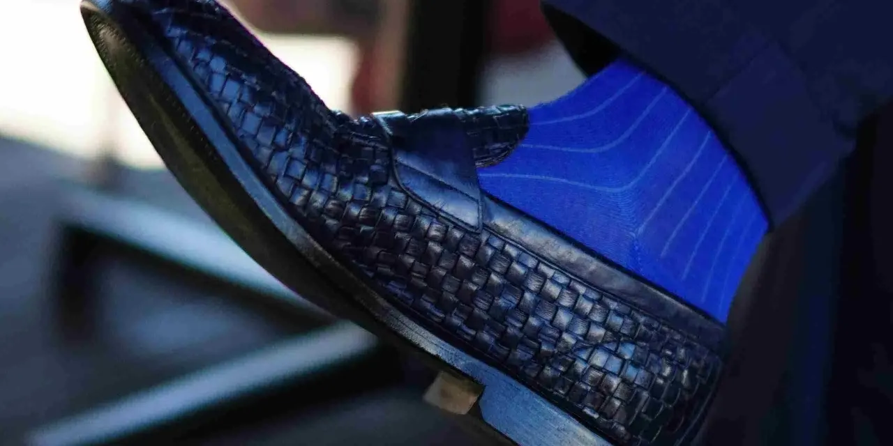 Scarpe blu intrecciate con calzini blu a righe: un abbinamento elegante per un look sofisticato.