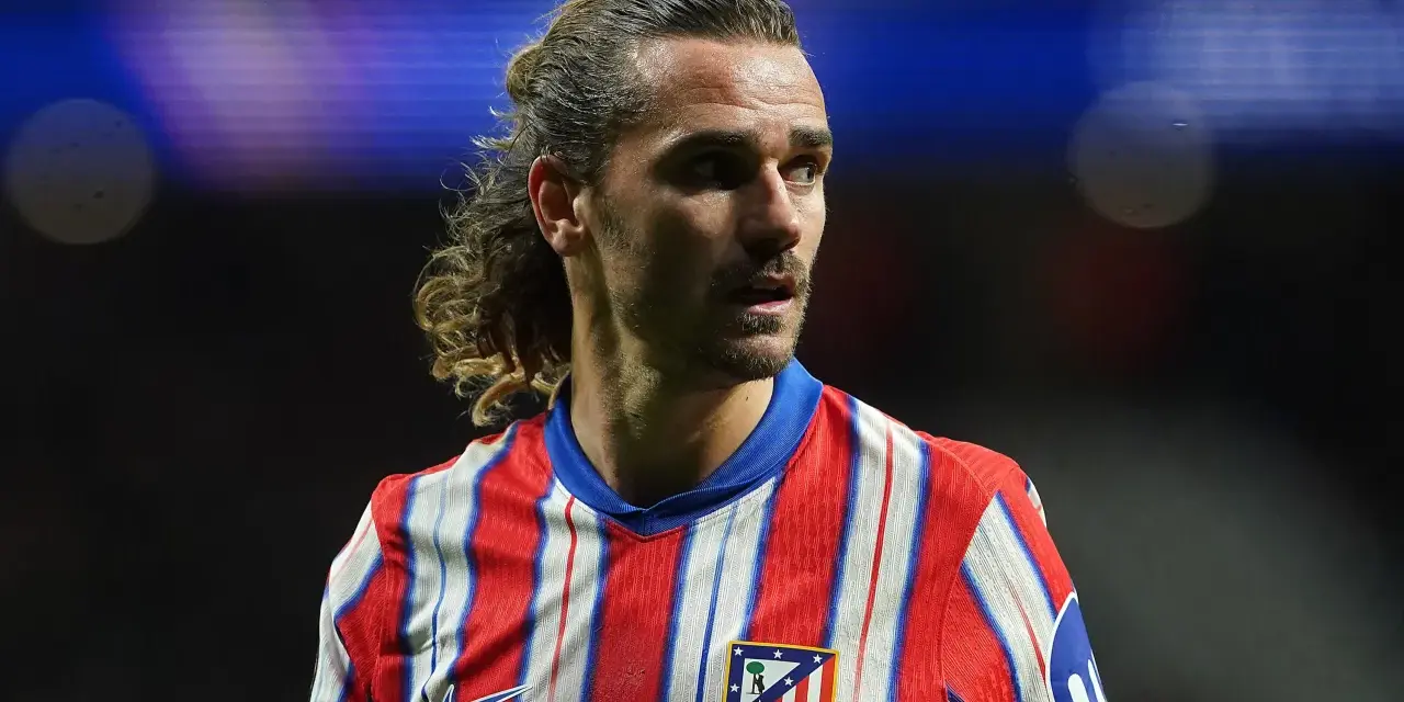 Grizman w koszulce Atletico Madryt, z charakterystyczną fryzurą, skupiony na boisku.