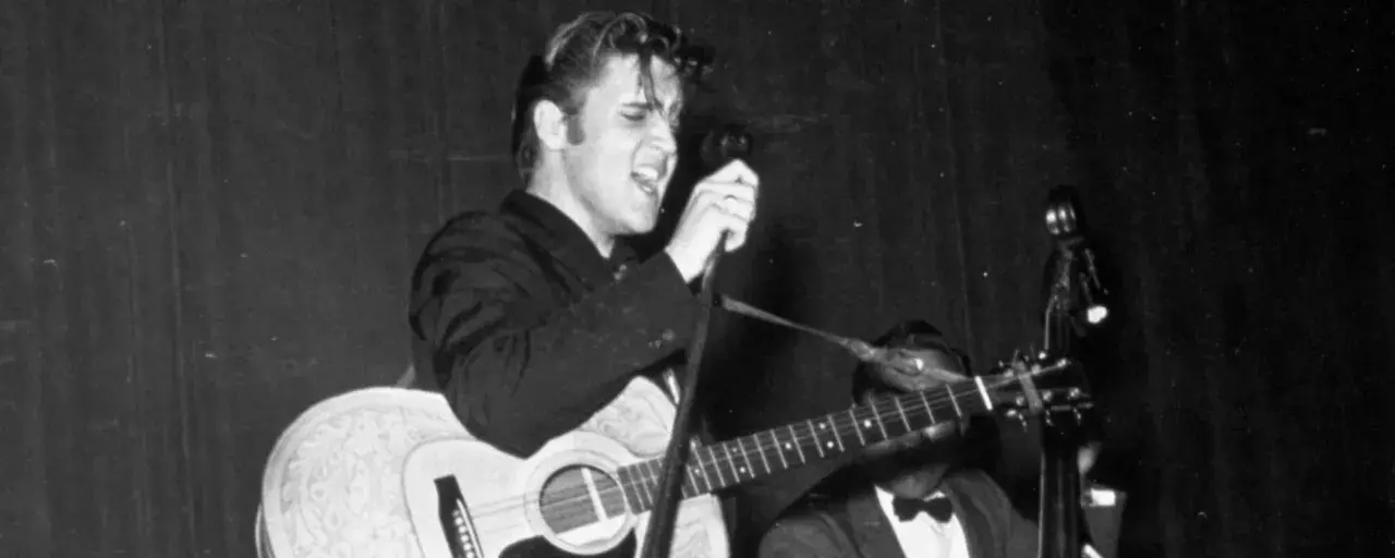 Elvis Presley singt mit Leidenschaft und spielt Gitarre. Ein historischer Moment, vielleicht sein erster Song.