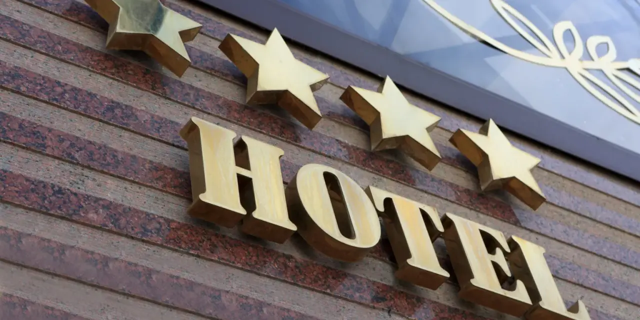 Złote gwiazdki nad napisem HOTEL. To one decydują, kto nadaje gwiazdki hotelom, wskazując na jego standard.