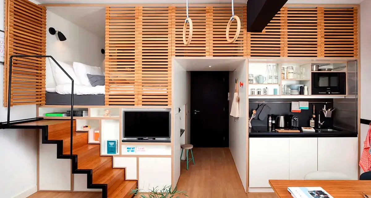 Acogedor apartamento con **dormitorios con techos altos** elevados, escaleras de madera, cocina compacta y zona de estar.