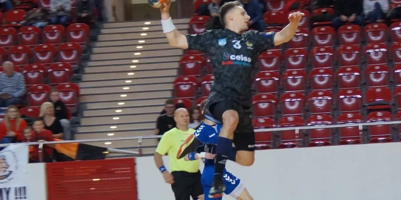 Kacper Grabowski w skoku do rzutu piłką ręczną, próbuje pokonać obronę przeciwnika.