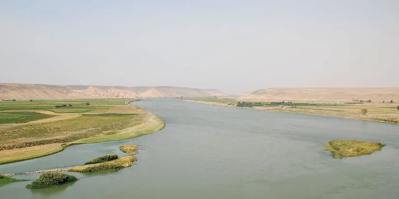 El río Éufrates serpentea entre fértiles campos verdes y áridas colinas.