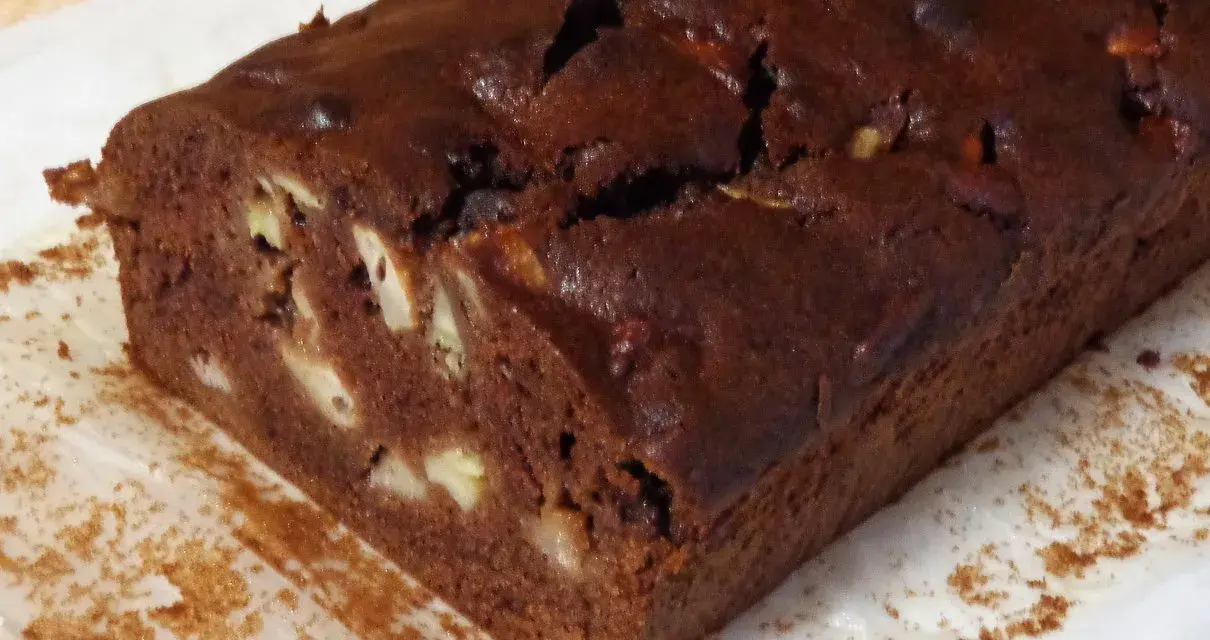 Wilgotne ciasto czekoladowe z bananami, z widocznymi kawałkami owoców w środku.