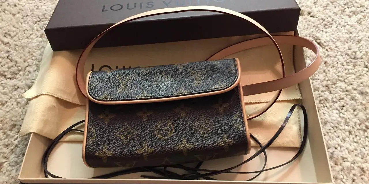 Mała torebka Louis Vuitton w brązowym monogramie, w pudełku z logo marki.