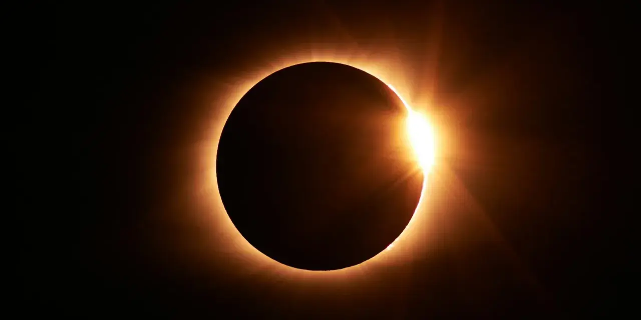 Eclipse solar total, con el sol brillando intensamente alrededor del disco lunar. El **nodo norte y nodo sur** celestes se alinean para este espectáculo.