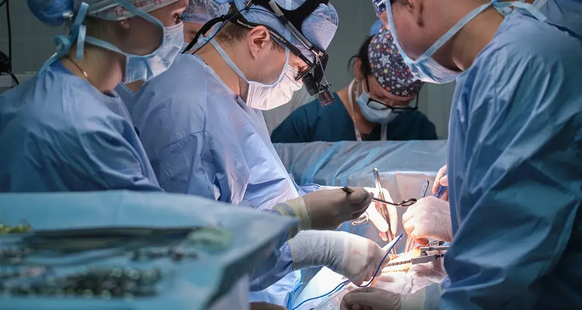 Zespół medyczny w akcji, skupiony na precyzyjnym pielęgniarstwie chirurgicznym.