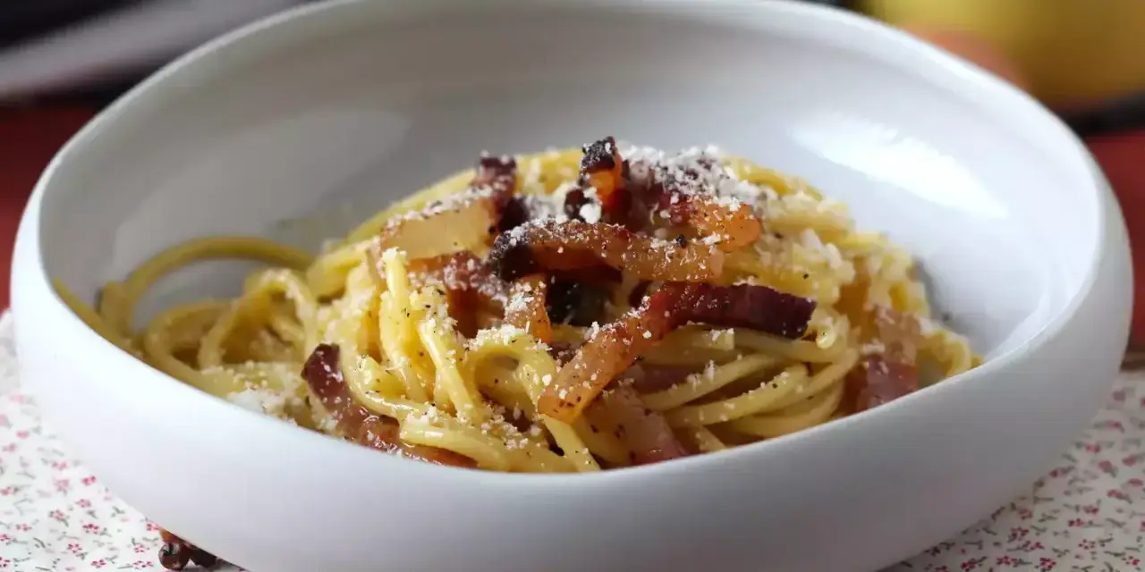 Spaghetti cremosi con guanciale croccante e pecorino, un'autentica ricetta della carbonara.