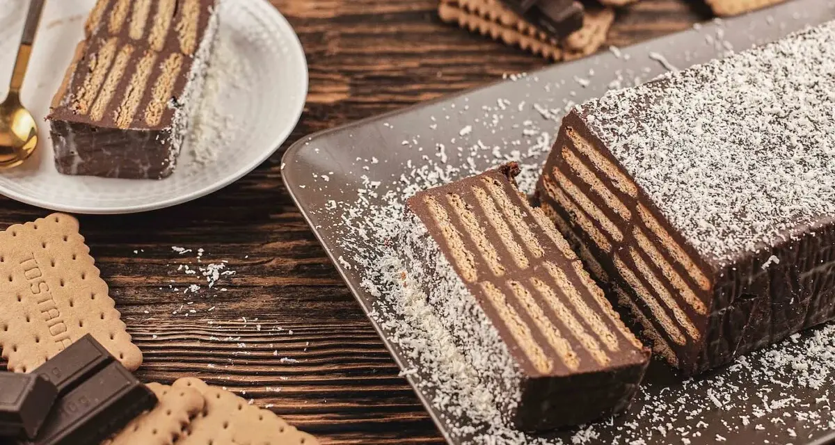 Tarta de chocolate y galletas, un postre casero con capas de galletas y crema de chocolate, espolvoreada con coco rallado.