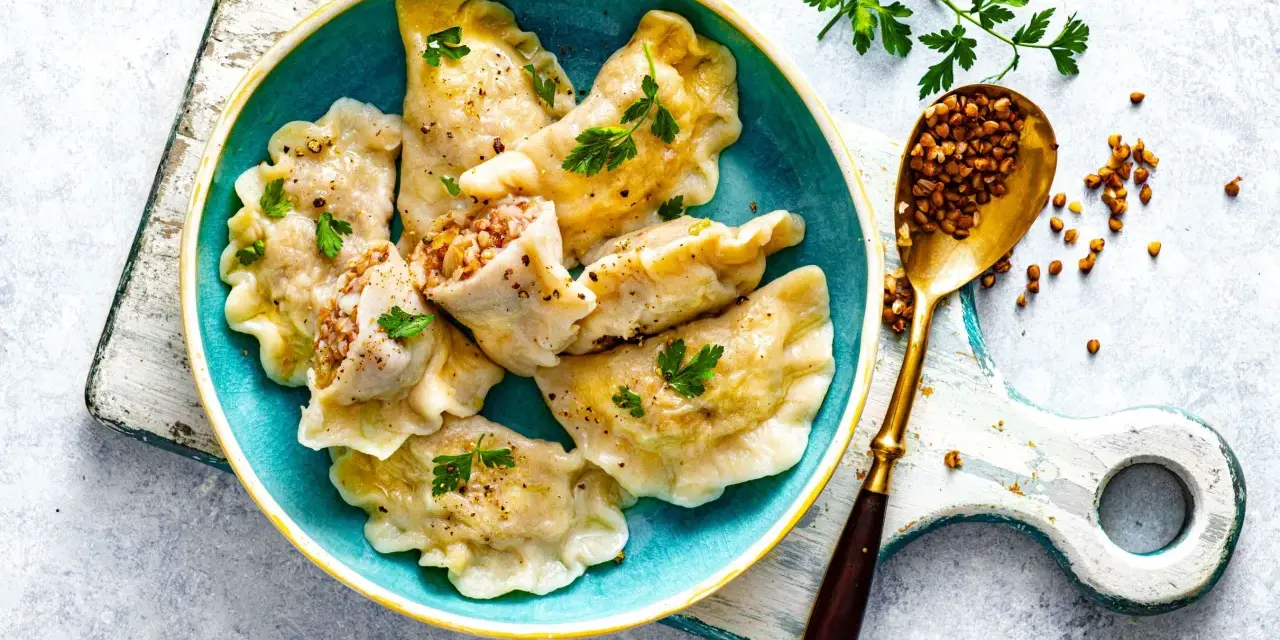 Sprawdzony przepis na pierogi z kaszą gryczaną i serem. Pyszne, domowe pierogi z bogatym nadzieniem, ozdobione natką pietruszki.