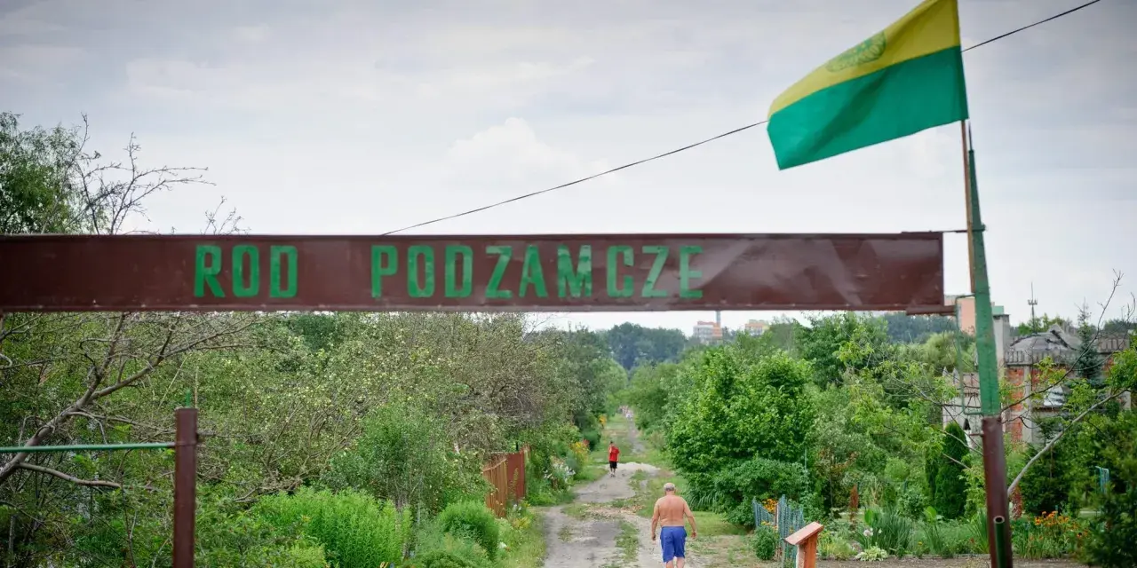 Kto stoi za kampanią "wolne działki ROD"? Czy protesty zablokują nowe przepisy? Wjazd do ROD Podzamcze, gdzie widać mężczyznę idącego ścieżką.