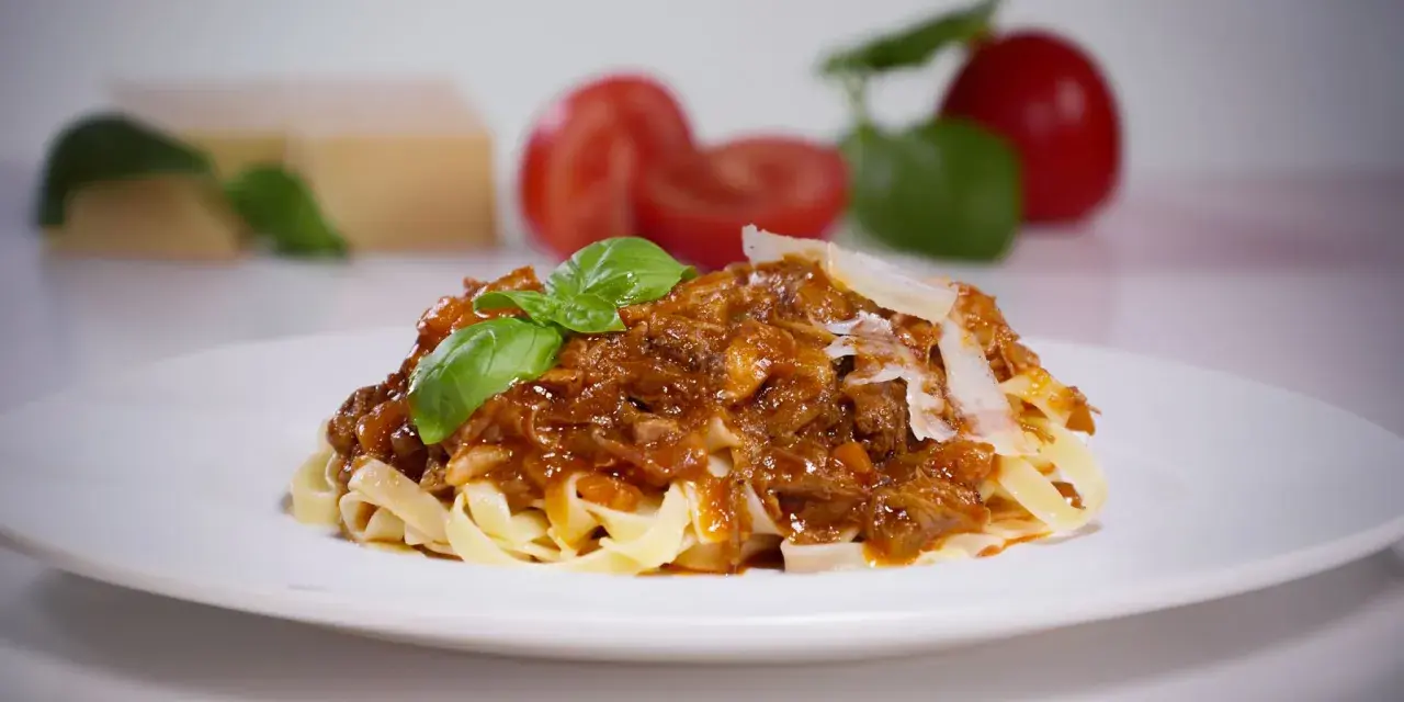 Tagliatelle mit Bolognese, ein Gericht, das die Essenz der Accademia Italiana della Cucina Bolognese verkörpert.
