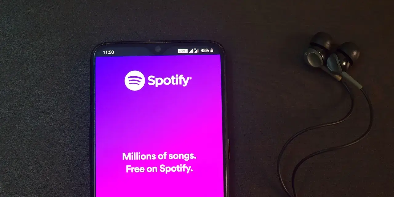 Telefon z aplikacją Spotify i słuchawkami. Idealne do słuchania wzruszających piosenek o przyjaźni.