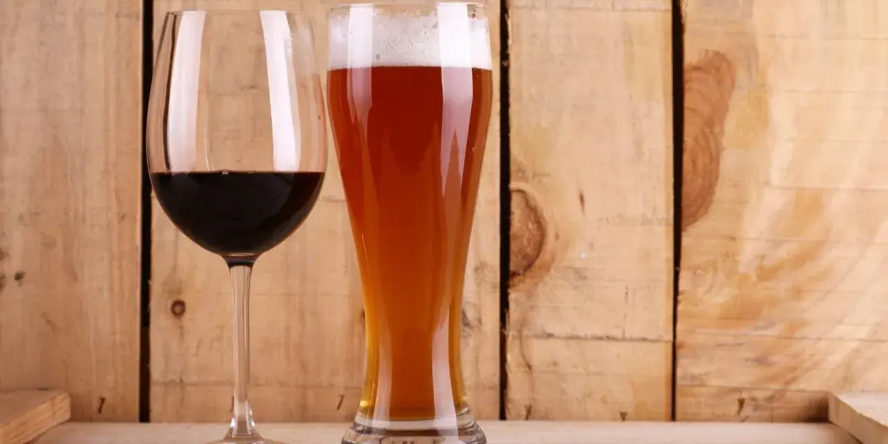 Copa de vino tinto y vaso de cerveza dorada con espuma. ¿Qué engorda más la cerveza o el vino? La respuesta está en las calorías.