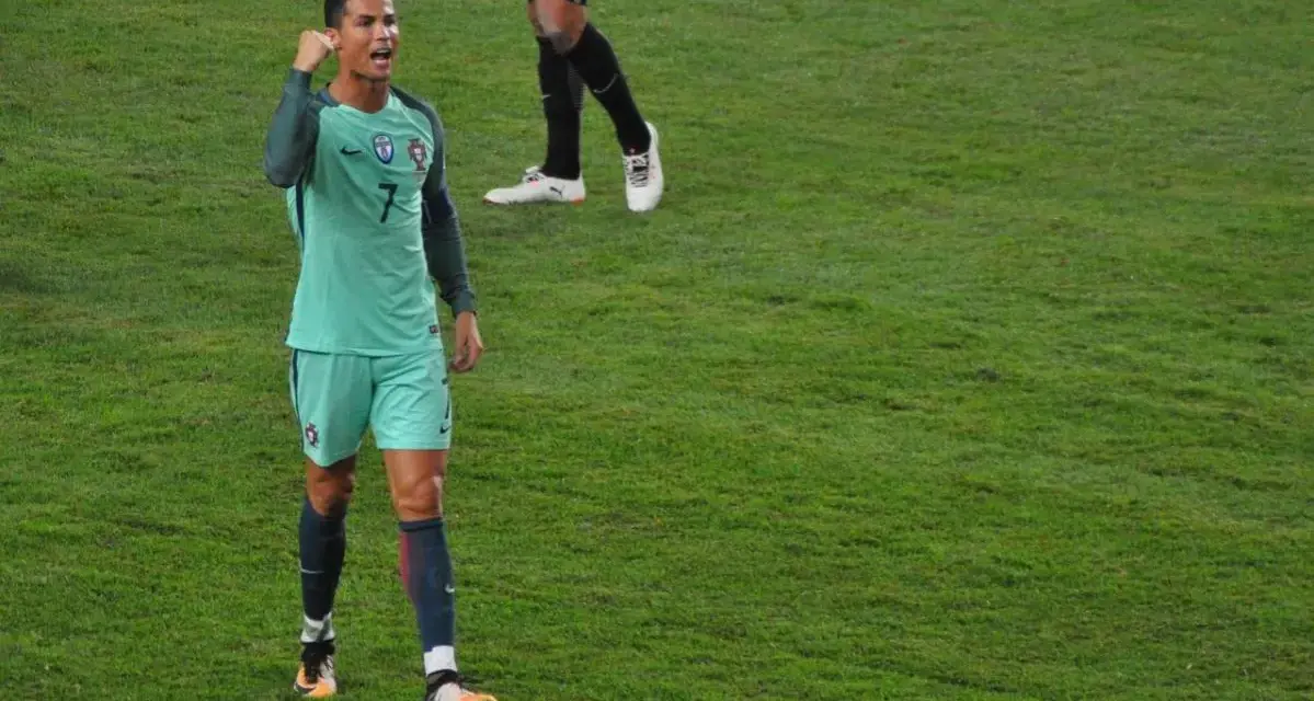 Cristiano Ronaldo w zielonej koszulce z numerem 7, cieszy się po golu. Ciekawe, ile zarabia Ronaldo za takie emocje!