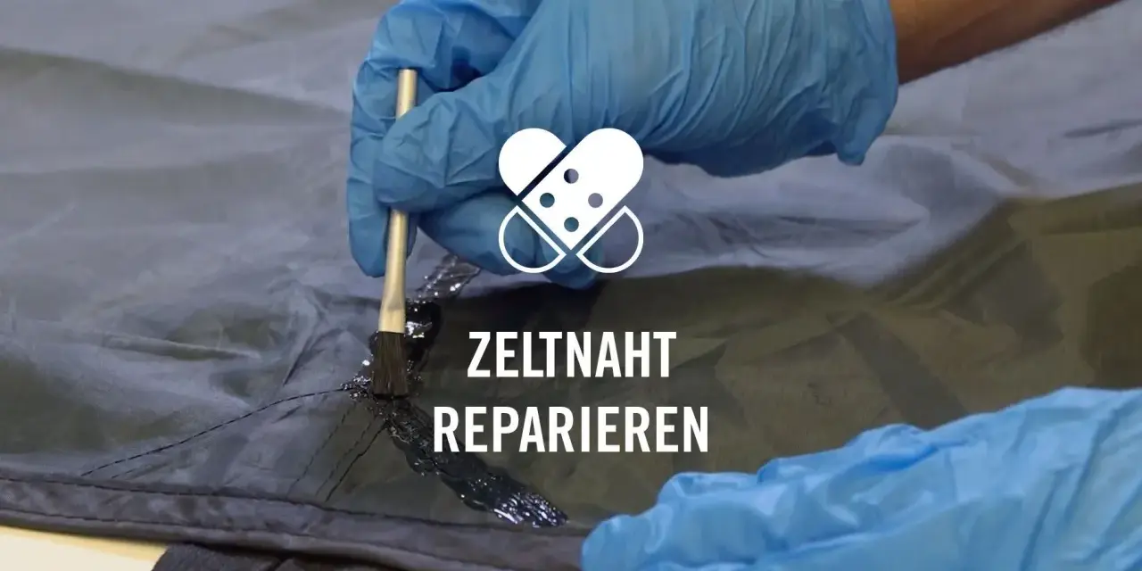 Mit einem Pinsel wird eine schwarze Dichtmasse auf eine Zeltnaht aufgetragen, um sie abzudichten und zu reparieren.