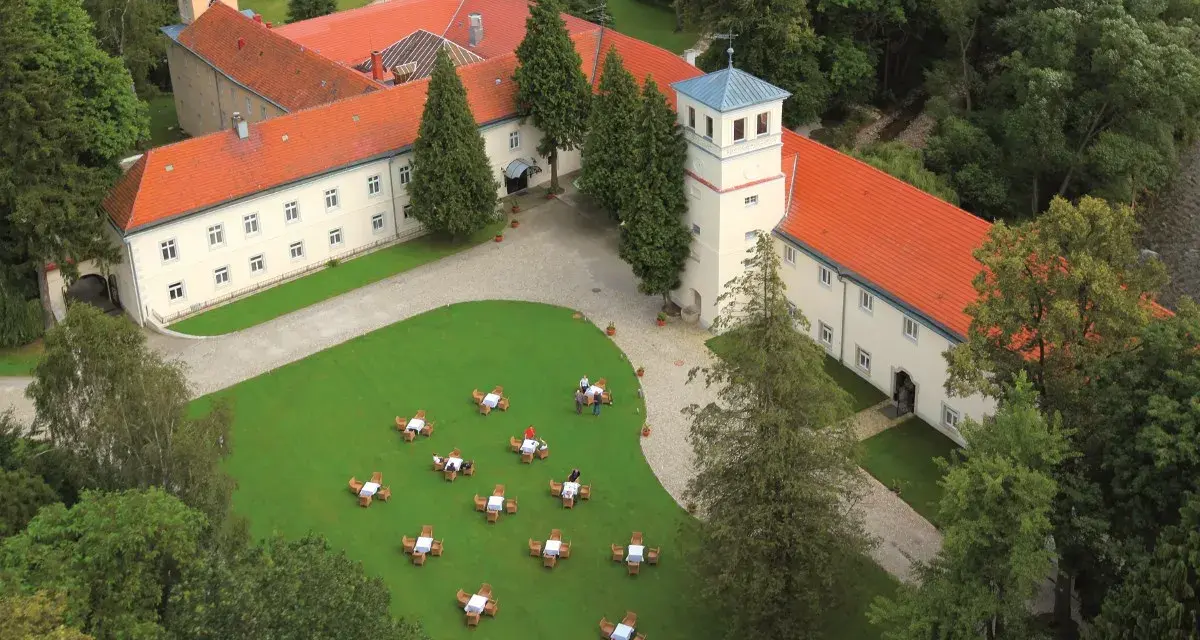 Trzebieszowice zamek na skale, otoczony zielenią, z dziedzińcem i ogródkiem kawowym.