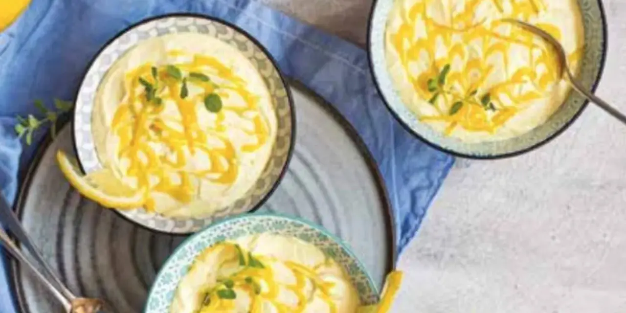 Tre coppette di deliziosa mousse al limone, guarnite con scorza di limone e menta fresca.