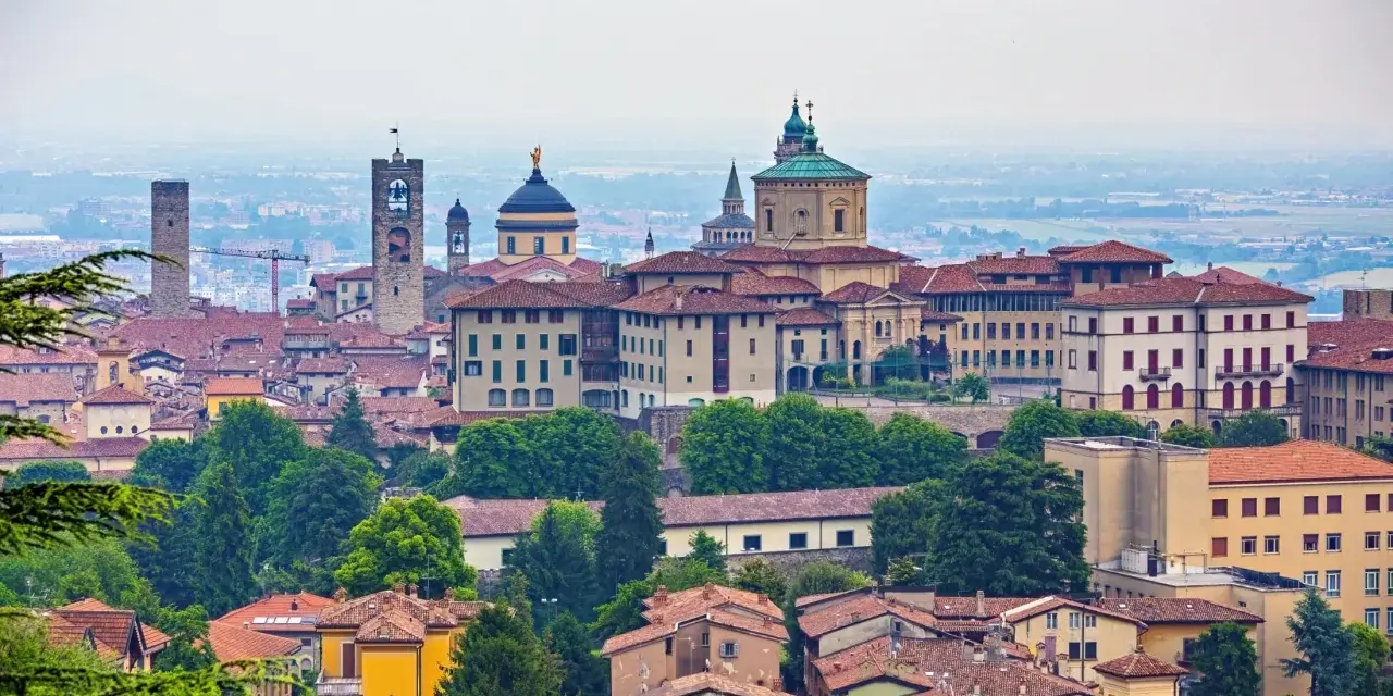 Panorama Bergamo, gdzie zwiedzić warto zabytkowe wieże i kopuły. Miasto zachwyca architekturą i zielenią.