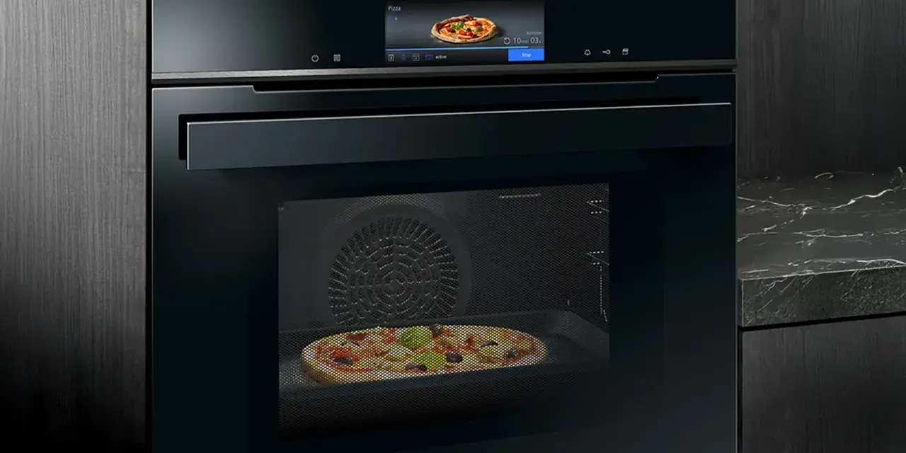 Modern ugn med touchskärm som visar en pizza. Denna Siemens studioline ugn har ångfunktion för perfekt bakning.