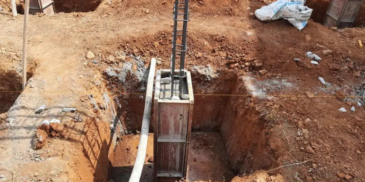 Wykop pod fundament słupowy, zbrojenie i szalunek gotowe do zalania betonem.