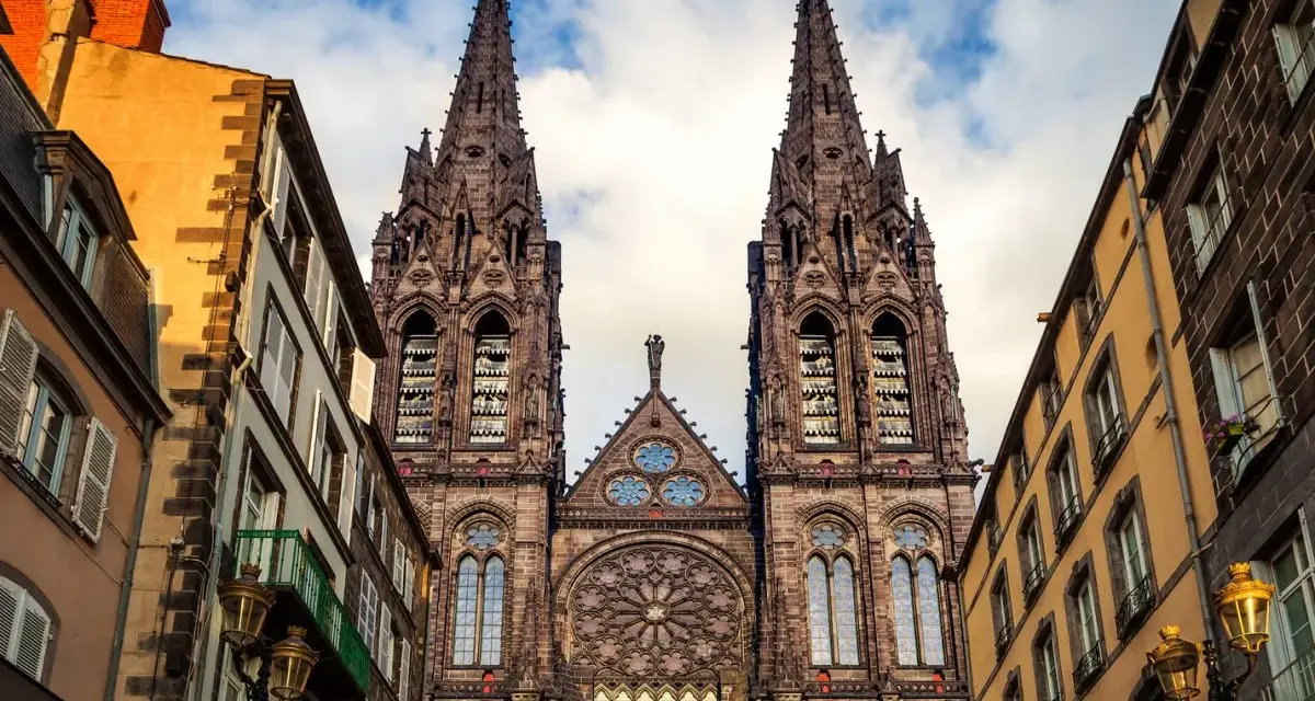 La cathédrale de Clermont-Ferrand, une des plus belles cathédrales de France, se dresse fièrement entre des immeubles anciens.