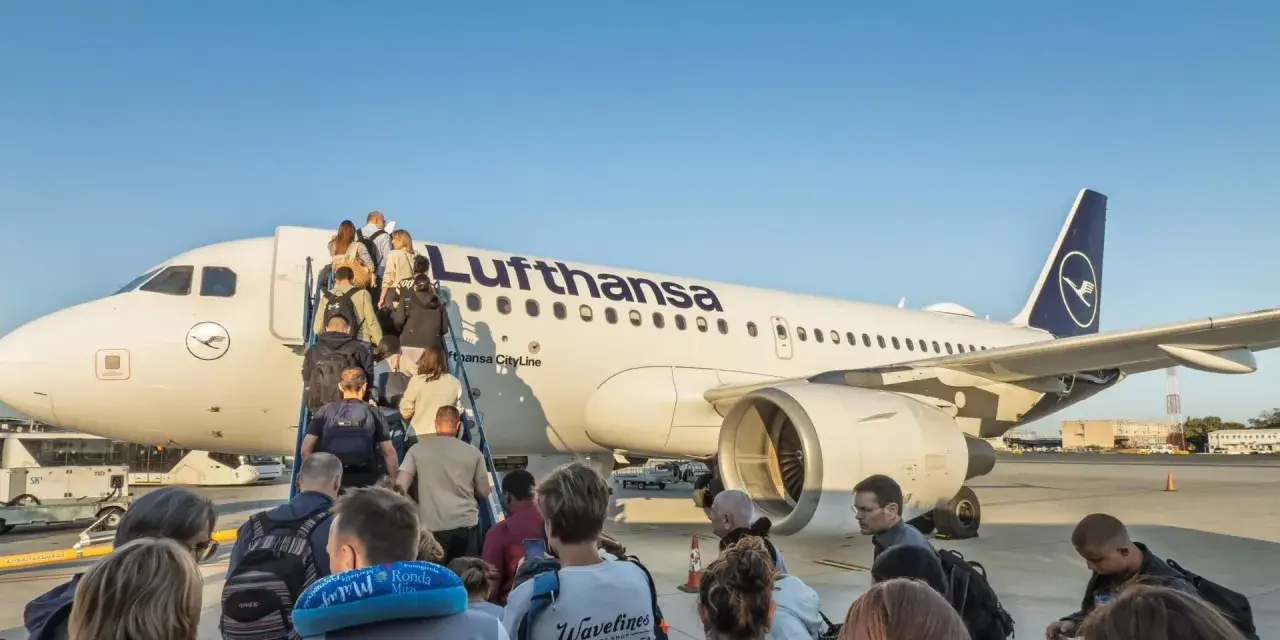 Pasażerowie wsiadają po schodkach do samolotu Lufthansa.