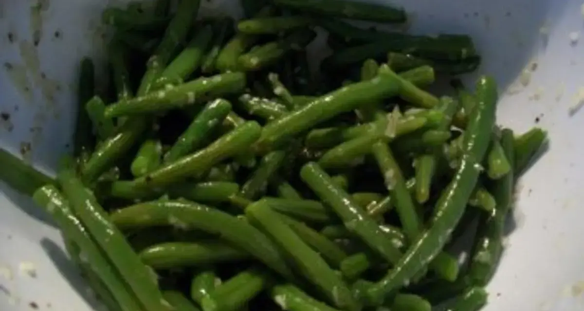 Ein klassisches Bohnensalat Rezept, frisch zubereitet. Grüne Bohnen mit feinen Gewürzen in einer Schüssel.