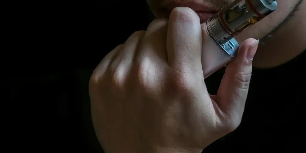 Persona probando un vaper, mostrando varios modelos de vaper en su mano.